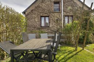 a wooden table and chairs in front of a house at Maison Kaoz Korriganez in La Boussac