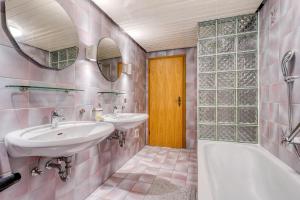 a bathroom with two sinks and a tub and a yellow door at Am Linnert in Haltern +19 photos