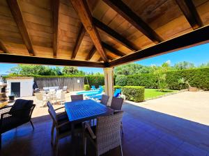 a patio with a table and chairs and a pool at Finca Boy in Pollença