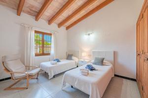 a room with two beds and a chair in it at Finca Boy in Pollença +33 photos