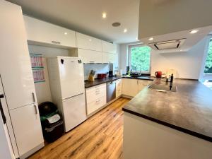 a large kitchen with white appliances and wooden floors at Citynah und Chic bei Hamburg in Norderstedt
