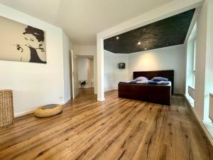 a bedroom with a bed and a hard wood floor at Citynah und Chic bei Hamburg in Norderstedt