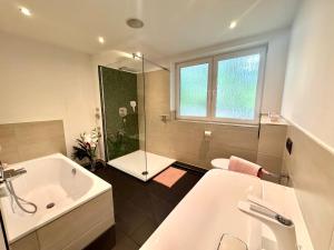 a bathroom with a tub and a sink and a shower at Citynah und Chic bei Hamburg in Norderstedt +9 photos