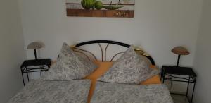 a bed with two pillows on it with two tables at Ferienhaus Stahlberg in Potsdam