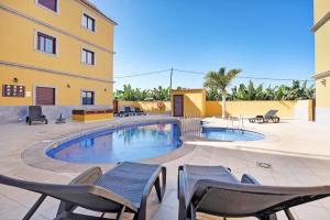 a patio with chairs and a swimming pool at Cozy Tazacorte in Tazacorte