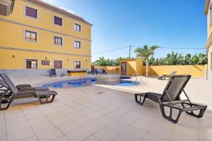 a patio with chairs and a pool in front of a building at Cozy Tazacorte in Tazacorte