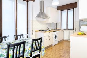a kitchen with a table and chairs in a kitchen at Luna - Apartment by the beach in Lesa