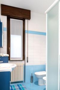 a blue and white bathroom with a toilet and a sink at Luna - Apartment by the beach in Lesa +21 photos