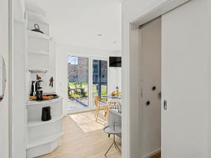 a kitchen with white cabinets and a dining room at Apartment Seemomente - 615 by Interhome in Lembruch +25 photos