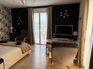 a bedroom with a bed and a desk with a computer at Studio Sablé sur Sarthe in Sablé-sur-Sarthe