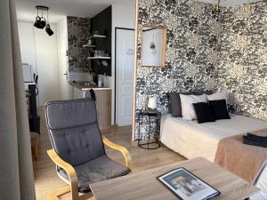 a living room with a bed and a chair at Studio Sablé sur Sarthe in Sablé-sur-Sarthe