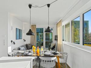 a dining room with a table and chairs and windows at Apartment Seeflair by Interhome in Lembruch