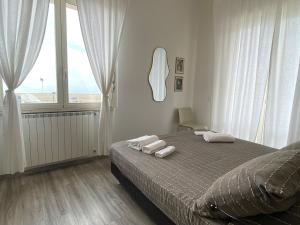 a bedroom with a bed with white towels on it at A7 Trilocale Fronte Mare in Marina di Grosseto