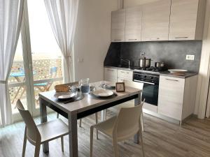 a kitchen with a table and chairs and a stove at A7 Trilocale Fronte Mare in Marina di Grosseto +9 photos