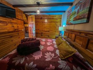 ein Schlafzimmer mit einem großen Bett in einer Blockhütte in der Unterkunft Cabañas Lupita 22 in Mazamitla