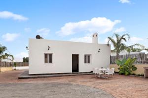 a white house with a table and chairs at Villa Montemedio - Paco in El Soto