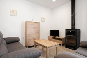 a living room with a couch and a table and a tv at Villa Montemedio - Paco in El Soto