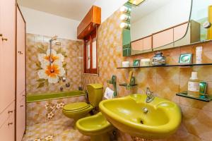 a bathroom with two yellow toilets and a sink at Le Logge - Bronte in Bronte +12 photos