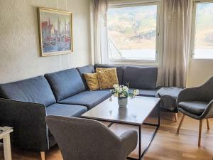 a living room with a blue couch and a table at Apartment Samlen Vasselgård by Interhome in Herand +30 photos