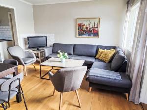 a living room with a blue couch and a table at Apartment Samlen Vasselgård by Interhome in Herand
