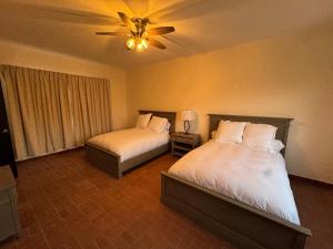 a bedroom with two beds and a ceiling fan at Villa Marines Cuernavaca in Cuernavaca +20 photos