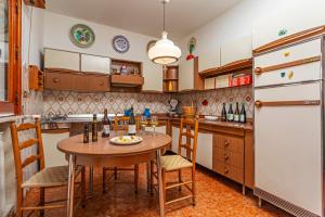 a kitchen with a table and a refrigerator at Le Logge - Bronte in Bronte