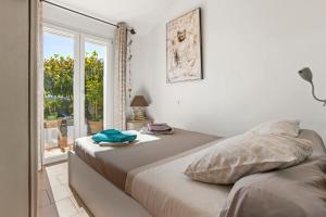 a bedroom with a bed and a large window at Gîte Les Tarentes avec piscine in Cotignac