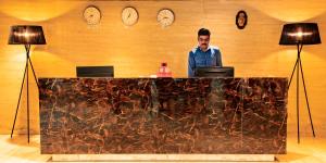 a man sitting at a desk with two laptops at Banyan Palace in Chennai