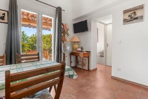 a living room with a table and a television at Gîte Les Tarentes avec piscine in Cotignac