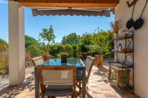 a table and chairs on a patio with a view at Gîte Les Tarentes avec piscine in Cotignac