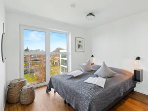 a bedroom with a bed and a large window at Apartment Penthouse Imort - 654 by Interhome in Lembruch