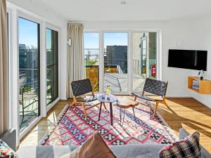 a living room with a table and chairs and a balcony at Apartment Penthouse Imort - 654 by Interhome in Lembruch