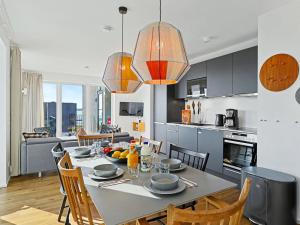 a kitchen and dining room with a table and chairs at Apartment Penthouse Imort - 654 by Interhome in Lembruch