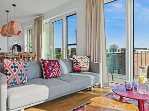 a living room with a gray couch and a balcony at Apartment Penthouse Imort - 654 by Interhome in Lembruch +33 photos
