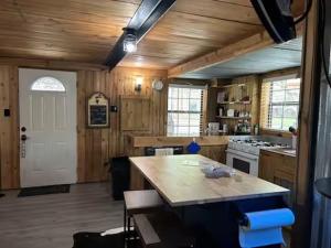a large kitchen with wooden walls and a white door at Prickly Pear - Rustic Cabin in New Braunfels