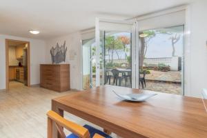 a kitchen and dining room with a wooden table and chairs at Planta Baixa in Platja d'Aro