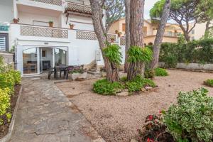 a garden with trees and a patio with a table at Planta Baixa in Platja d'Aro