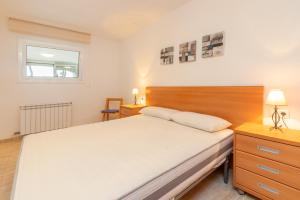 a bedroom with a bed and a dresser and a window at Planta Baixa in Platja d'Aro