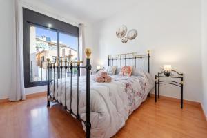 a bedroom with a bed and a large window at Apartamentos de Ángel in Vinebre