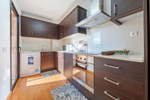 a large kitchen with wooden cabinets and a counter top at Apartamentos de Ángel in Vinebre