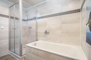a bathroom with a tub and a shower at Auszeit Nr 18 in Zempin +16 photos