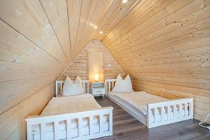 two beds in a room with a wooden ceiling at Auszeit Nr 18 in Zempin