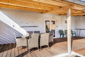 a patio with a table and chairs on a deck at Auszeit Nr 18 in Zempin