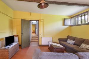 a living room with a couch and a tv at Can Marc in Dosríus