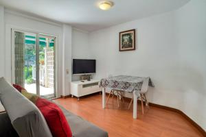 a living room with a table and a tv at Nice apartment with terrace in Lloret de Mar