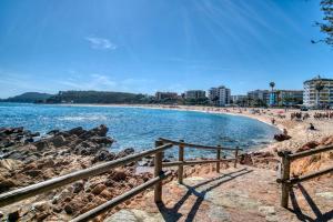 a beach with a fence next to the water at Nice apartment with terrace in Lloret de Mar