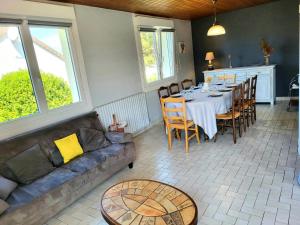 a living room with a table and a couch at Maison De Bord De Mer Alizée in Saint-Germain-sur-Ay
