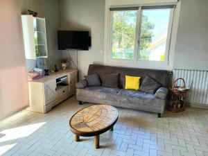 a living room with a couch and a coffee table at Maison De Bord De Mer Alizée in Saint-Germain-sur-Ay