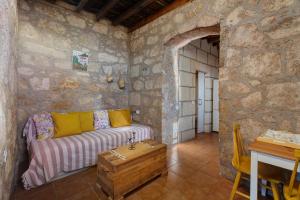 a living room with a couch in a stone wall at Eco Holidays House Races in Fasnia
