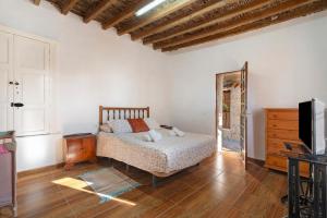 a bedroom with a bed and a dresser and a television at Eco Holidays House Races in Fasnia